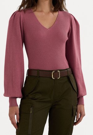 Sweater en tricot côtelé rose avec un col en V et des manches longues bouffantes, associé à un pantalon cargo vert foncé avec une ceinture marron et une boucle en or.
