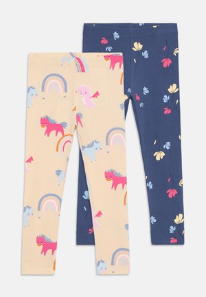 Twee paar leggings: de ene beige met kleurrijke eenhoorn- en regenboogprints, de andere marineblauw met bloemenontwerpen. Gemaakt van zachte, rekbare stof.