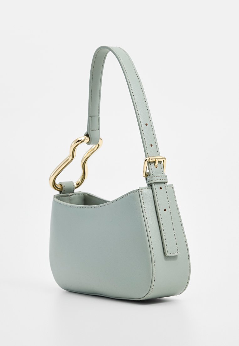Mintgrüne Lederhandtasche mit geschwungener Silhouette, ausgestattet mit einem skulpturalen Griff in Gold und einem verstellbaren Riemen. Glatte Textur und minimalistisches Design.