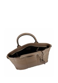 Leather tote bag in light beige with a smooth texture, double handles, and a zip closure. Interior is black, featuring a small hanging tag.