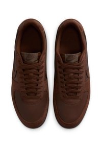 Zapatillas Nike marrones que combinan ante texturizado y cuero suave, con punta redondeada y cordones planos, además de una etiqueta con el logo en la lengua.