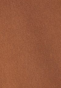 Zachte, gestructureerde stof in een warme, verbrande oranje kleur met een subtiel geweven patroon en fijne, verhoogde draden door het hele oppervlak.