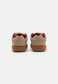 Adidași din suede bej cu interior vinocat, au o talpă din cauciuc texturat și un design minimalist cu detalii de cusătură subtile.