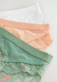 Spetstrosor i vitt, persika och grönt; har elastiska midjeband och intrikata spetstillägg. Texturerade och semigenomskinliga material.