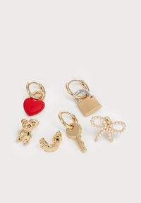 Fem guldfarvede charms: et rødt hjerte, en bamse, en nøgle, en hængelås og en perle-accentueret sløjfe, hver med unikke former og teksturer.