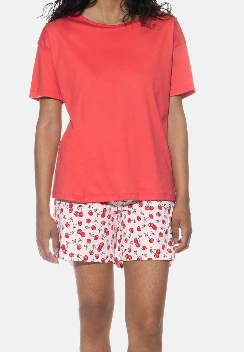 Rotes Baumwoll-T-Shirt mit kurzen Ärmeln, kombiniert mit pinken Shorts mit einem Kirschmuster und schwarzen Konturen, weicher Textur, lässige Passform.