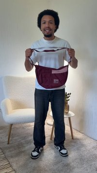 Borsa a tracolla color mogano con molteplici tasche, caratterizzata da una patch accentata rosa chiaro, spallacci regolabili e tessuto resistente.