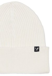 Bonnet blanc côtelé avec un revers, fabriqué en matière tricotée. Présente une petite étiquette noire avec un emblème d'outils croisés sur le revers.