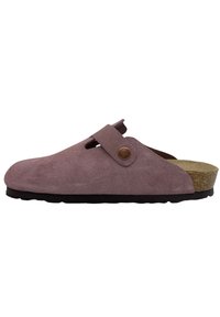 Bottines en daim rose avec un bout rond, une large ouverture, une sangle ajustable et une semelle en liège, reposant sur une semelle noire texturée.