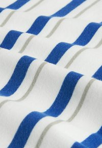 Tissu doux avec des rayures horizontales bleues et gris clair sur un fond blanc, présentant de légers plis.