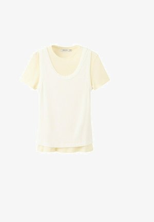 T-shirt crème à manches courtes superposée avec un débardeur côtelé sans manches, tous deux avec des encolures rondes, présentés sur un fond blanc.