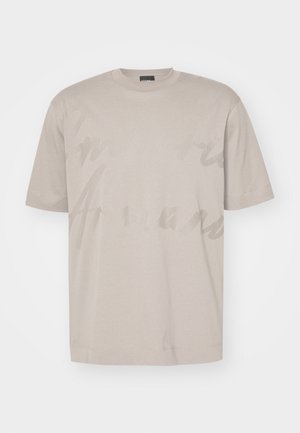 T-shirt di cotone beige con maniche corte e scollo rotondo. Presenta un grande motivo di testo sottile sulla parte anteriore. Texture liscia.