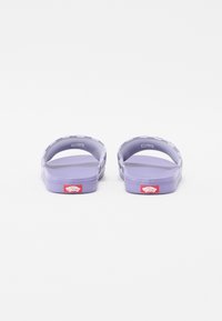 Fialové šľapky na slip-on s textúrovanou podrážkou, otvoreným zadným dizajnom a akcentami loga Vans na päte. Vyrobené z flexibilného materiálu.