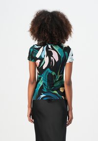 Kurzärmliges Oberteil mit floralem Design in Grün, Pink und Schwarz, aus weichem Stoff mit figurbetontem Schnitt und subtiler glänzender Oberfläche.