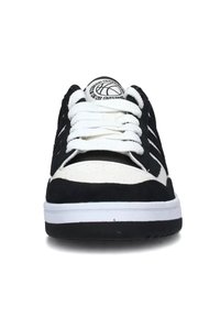 Sort-hvide sports sneakers med en overdel i ruskind og læder, markante snørebånd, en rund tå og en tekstureret gummisål.