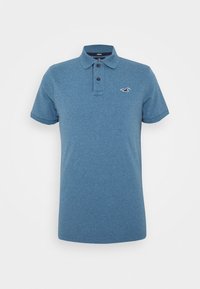 Modrá polo košile s texturovanou tkaninou, dvouknoflíkovým zapínáním, krátkými rukávy a malým vyšitým logem na levé hrudi.