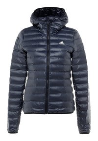 Veste matelassée bleu marine avec capuche et fermeture éclair complète. Présente un design matelassé horizontal texturé et un petit logo blanc sur la poitrine.