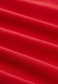 Rode stof met een gladde textuur, met zichtbare horizontale plooien. De kleur is levendig en uniform, zonder patronen of accenten.