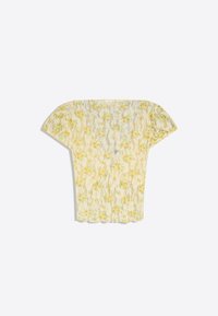 Blouse jaune en dentelle florale à manches courtes avec épaules bouffantes et ourlet festonné sur fond blanc.