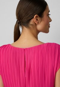 Fuchsia-Faltenkleid mit weitem Ausschnitt und Schlüsselrückenöffnung. Leichtes Material, kurze Ärmel und detaillierte Textur im gesamten Kleid.