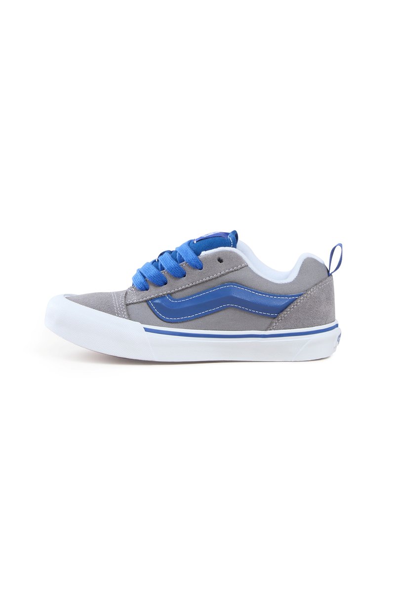 Šedá plátěná bota s modrými tkaničkami, bílou gumovou podrážkou a modrým designem na boční straně. Obsahuje poutko na patě pro snadné obutí.