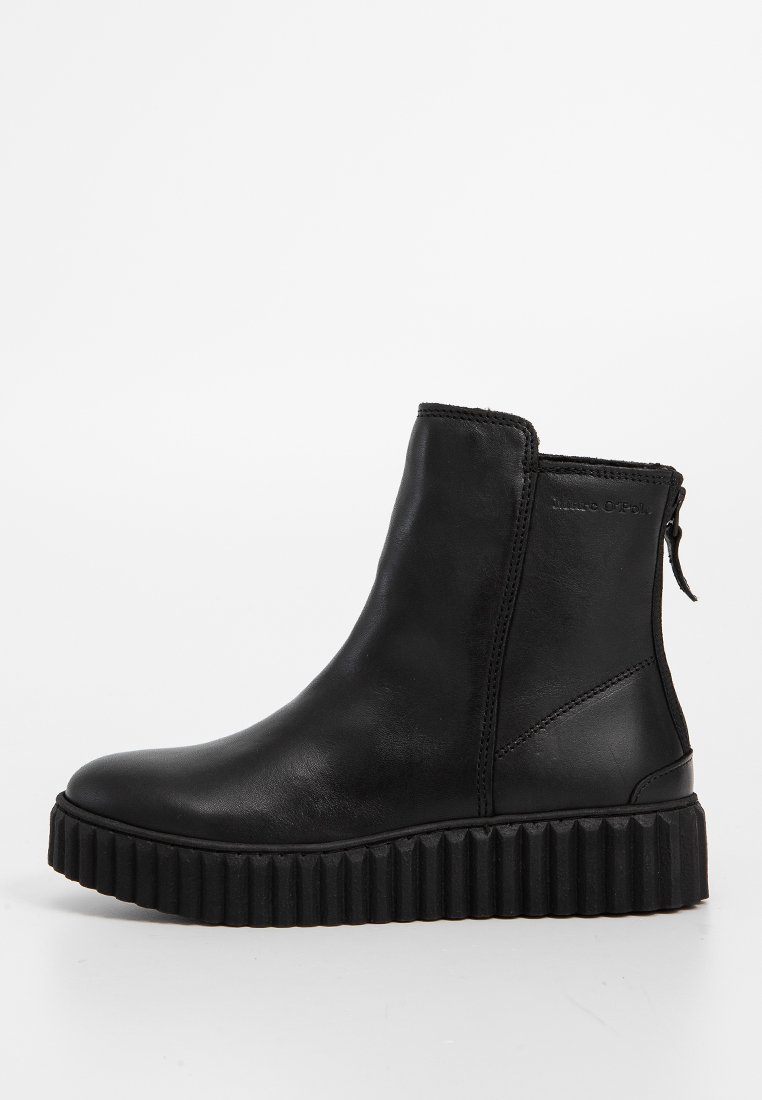 Schwarze Lederstiefeletten mit flacher, gerippter Sohle, seitlichem Reißverschluss und glatter Textur. Minimalistisches Design mit dezenten Nähakzenten.