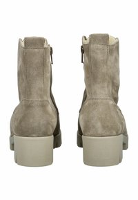 Bruine suède enkellaarsjes met een getextureerde afwerking, een zijrits en een chunky beige zool. Zachte voering zichtbaar bij de bovenrand.