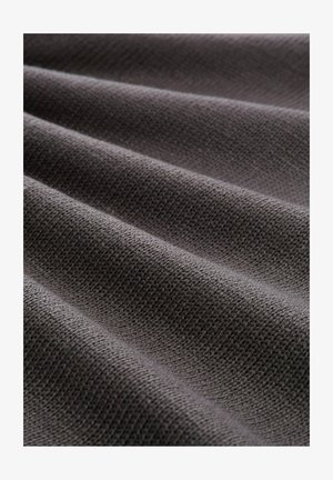 Tejido gris con una textura entrelazada, que muestra pliegues pronunciados y una superficie lisa. El color parece uniforme sin patrones o acentos visibles.