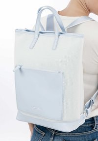 Šviesiai mėlynas tinklinis kuprinės modelis su odiniais akcentais. Yra dvi rankenos, reguliuojamos petnešos ir priekinis užtrauktukas, skirtas papildomam saugojimui.