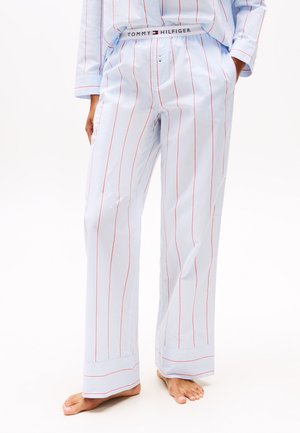 Pantalones de pijama azul claro con rayas verticales rojas, con una cinturilla elástica que lleva la marca "TOMMY HILFIGER". Corte suelto y recto.