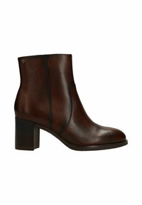 Brown leather ankle boot with block heel, side stitching, and small round metal brand emblem near top edge.