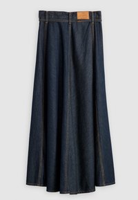 Džínová sukně v tmavě modré barvě s plným střihem, má vysoký pas a koženou nášivku na zadní straně. Kontrastní švy podél švů.