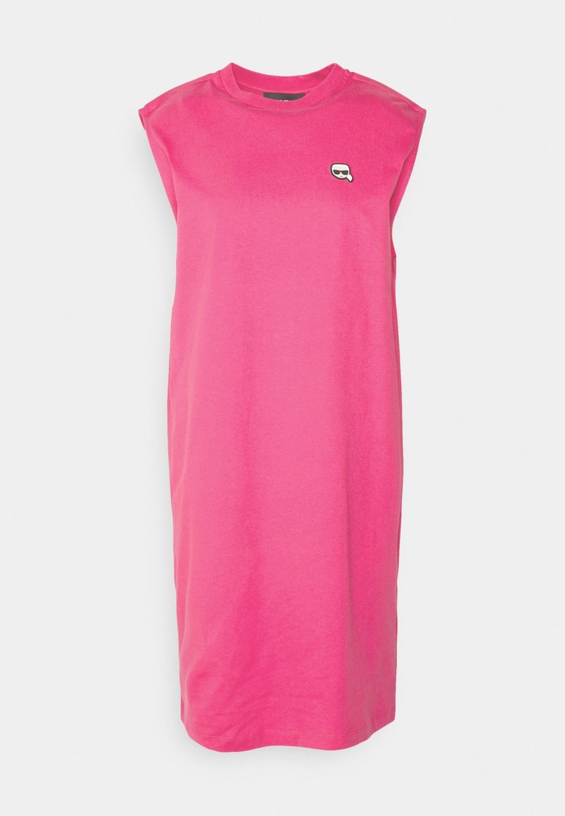 Robe sans manches, de longueur au genou, rose vif avec un petit logo noir et blanc représentant un visage avec des lunettes de soleil sur la poitrine supérieure.
