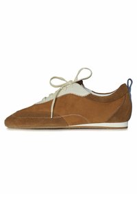 Scarpa in suede marrone con un accento in pelle bianca, sole piatto e punta tonda. Presenta lacci beige e una linguetta blu sul tallone. Dettaglio di cuciture testurizzate.