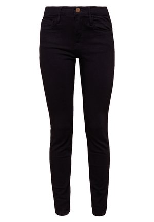 Valkoinen nappipaita mustilla kanin kuoseilla, mustat slim fit -farkut ja mustat korkokengät. Pieni musta olkalaukku metallisilla yksityiskohdilla.