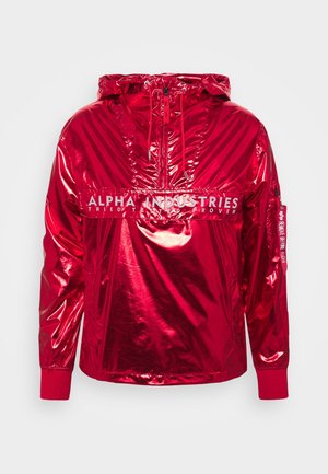 Giacca rossa lucida con cappuccio, cerniera frontale e stampa "Alpha Industries Tried Tested Proven" sul petto, polsini a costine e dettaglio con etichetta sulla manica.