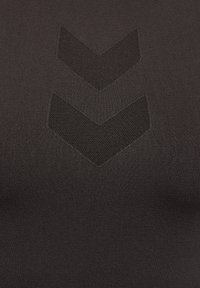 Czarny tekstyl z wzorem siatki z dwoma kształtami w formie szewronów wkomponowanymi w design, podkreślający fakturę i głębię.