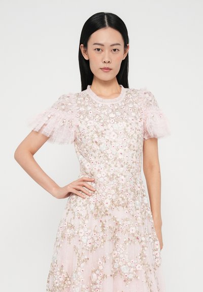 Lyserød kjole med gennemsigtig blomsterbroderi, korte flæseærmer, rund halsudskæring og flydende silhuet. Tekstureret stof med dekorative detaljer.