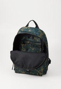 Sac à dos à motif floral en vert foncé et marine, doté d'une fermeture éclair et d'une doublure en tissu noir avec une poche avant. Léger et durable.