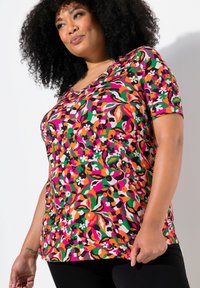 Košile s krátkým rukávem s živým květinovým vzorem v růžové, zelené a oranžové na černém pozadí, vyrobená z elastické tkaniny.