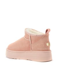 Różowe zamszowe botki za kostkę z miękką wyściółką wewnętrzną, podniesioną gumową podeszwą oraz małym dekoracyjnym uchwytem z tyłu. Posiadają szczegóły szwów.