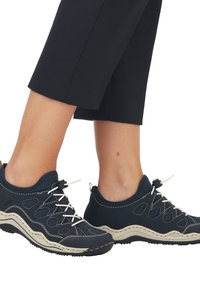 Marinblå mesh- och gummiskor med vita snören, förstärkt tå, texturerad sula och svängd beige mellansula, lämpliga för aktiv användning.