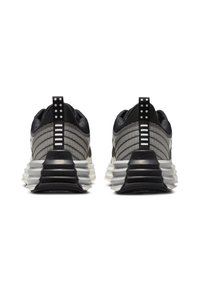 Svart och gråa sportskor med meshtopp, lager-på-lager sula och kontrasterande detaljer; baksidan har en tygöglor och märkning.