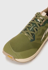 Chaussure de course légère verte avec tige en mesh, dotée de lacets ton sur ton, d'une semelle beige et de la marque Vibram sur la semelle pour l'adhérence.