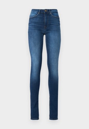 Jeans skinny em denim azul escuro. Design de cintura alta com detalhes de cinco bolsos, fecho de botão e desbotamento suave ao longo das pernas.