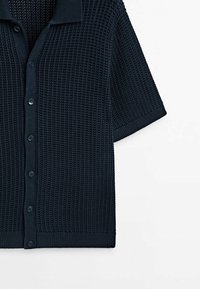 Cardigan en maille bleu marine à manches courtes avec motif gaufré, devant boutonné, col, poignets et ourlet côtelés.