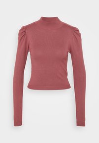 Haut à manches longues et col montant en rose poudré. Texture côtelée et coupe ajustée avec épaules bouffantes et ourlet court.