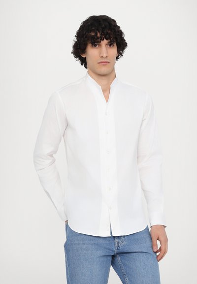 Hvit langermet skjorte med mandarin krage, med knapper og en glatt, jevn tekstur, parret med blå jeans.