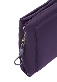 Fioletowa nylonowa torba o gładkiej teksturze, z zamknięciem na zamek i paskiem z materiału w paski na uchwycie zamka. Charakteryzuje się subtelnymi detalami szwów.