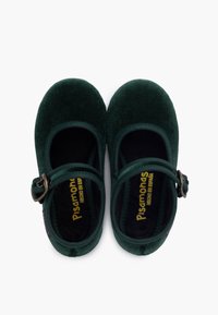 Zielone zamszowe buty Mary Jane z regulowanym paskiem i metalową sprzączką, wyposażone w miękką czarną wyściółkę i okrągły nos.